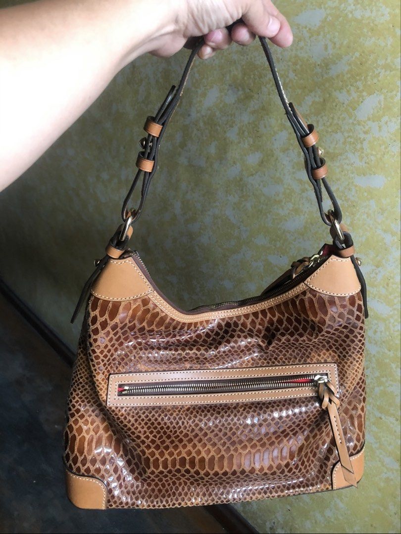 Dooney & Bourke Snakeskin Shoulder Bag (Category: Luxury Bags & Wallets) located in Quezon City. Submitted by cprmob (Listing ID 1436847090, Image 2). Description: - Dooney & Bourke shoulder bag - Snakeskin pattern with tan leather accents - Zip closure - Front exterior pocket - Red fabric lined interior - Multiple interior pockets - Shoulder strap - Small metal logo.