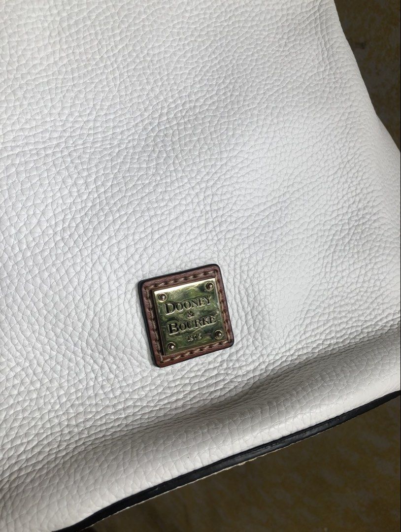 Dooney & Bourke White Leather Shoulder Bag (Category: Luxury Bags & Wallets) located in Quezon City. Submitted by cprmob (Listing ID 1436838277, Image 3). Description: - Dooney & Bourke shoulder bag - White leather exterior - Brown leather straps - Red interior with multiple pockets - Gold-colored brand emblem - Spacious interior - Comfortable shoulder strap.