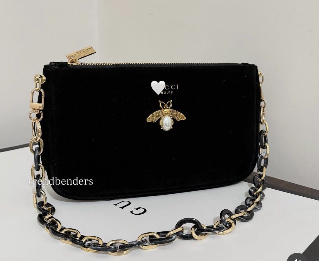 Gucci Velvet Bee Chain Bag (Category: Luxury Bags & Wallets) located in Iba. Submitted by geliqq (Listing ID 1436910398, Image 2). Description: - Black velvet handbag - Gold-tone chain strap - Decorative bee emblem - Gold zipper closure - Brand tag included - Black and gold chain links - Ideal for evening wear.