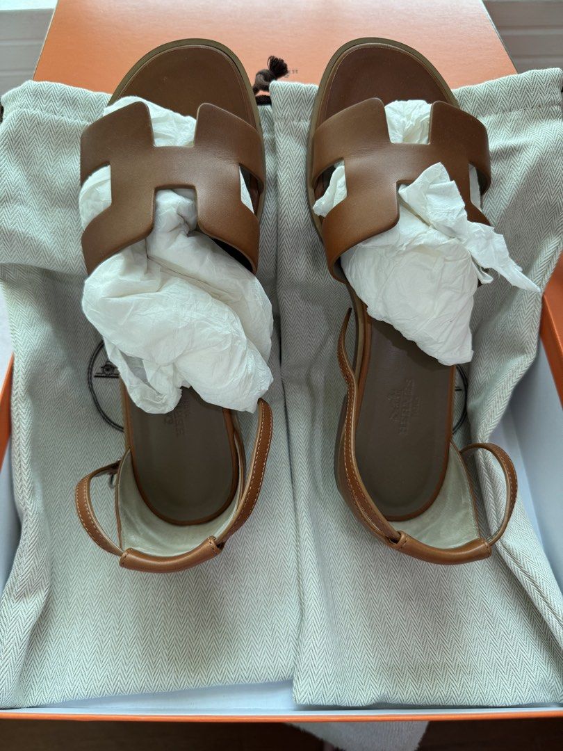 Hermes Santorini Caramel (Category: Sneakers & Footwear) located in Rizal. Submitted by christine122592 (Listing ID 1436828231, Image 2). Description: - Authentic Hermes Oran sandals - Color: Caramel - Includes original box, dust bag, and shopping bag - Features the iconic H-shaped cut-out - Ankle strap with buckle - Flat sole.