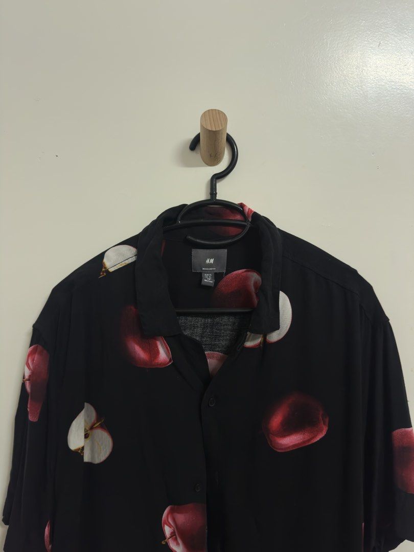 H&M Apple Print Shirt (Category: Tshirts & Polo Shirts ) located in Manila. Submitted by hutfris (Listing ID 1436896215, Image 3). Description: Black shirt from H&M with an apple print. It has short sleeves and a button-down front. The shirt has a collared neckline. The size is XL. The shirt is made of a lightweight material..
