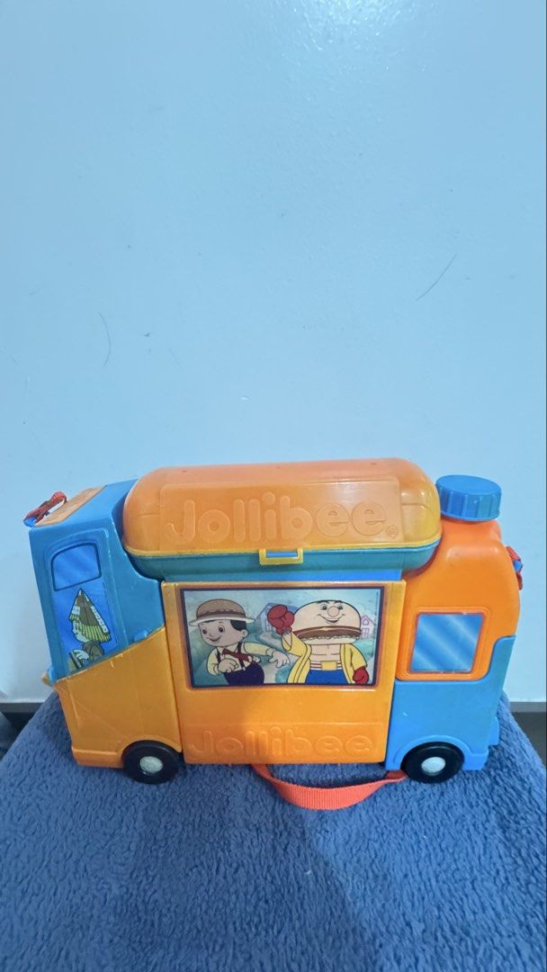 Jollibee Lunch Bus (Category: Vehicle & Diecast Models) located in Paranaque City. Submitted by pengkit (Listing ID 1436895311, Image 1). Description: - Missing spoon - Vintage Jollibee toy truck - Features Jollibee characters and logo - Orange and blue color scheme - Includes a carrying handle - Has wheels - Showcases Jollibee character images on windows - BURGER BOX - HOTDOG CAPSULE - FRIES POCKET - JOLLY JUG.