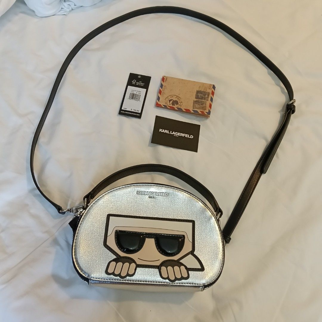 Karl Lagerfeld Silver Crossbody Bag (Category: Cross-body Bags) located in Mandaluyong City. Submitted by hailey143 (Listing ID 1436978017, Image 2). Description: - Karl Lagerfeld crossbody bag - Silver exterior with unique graphic design - Black strap and top handle - Black interior with small pocket - Comes with tags and a small card - Style: LH1EU9AI - MSRP: $198.00 - used once - RFS: 2 po pinadala sa akin 😊 .