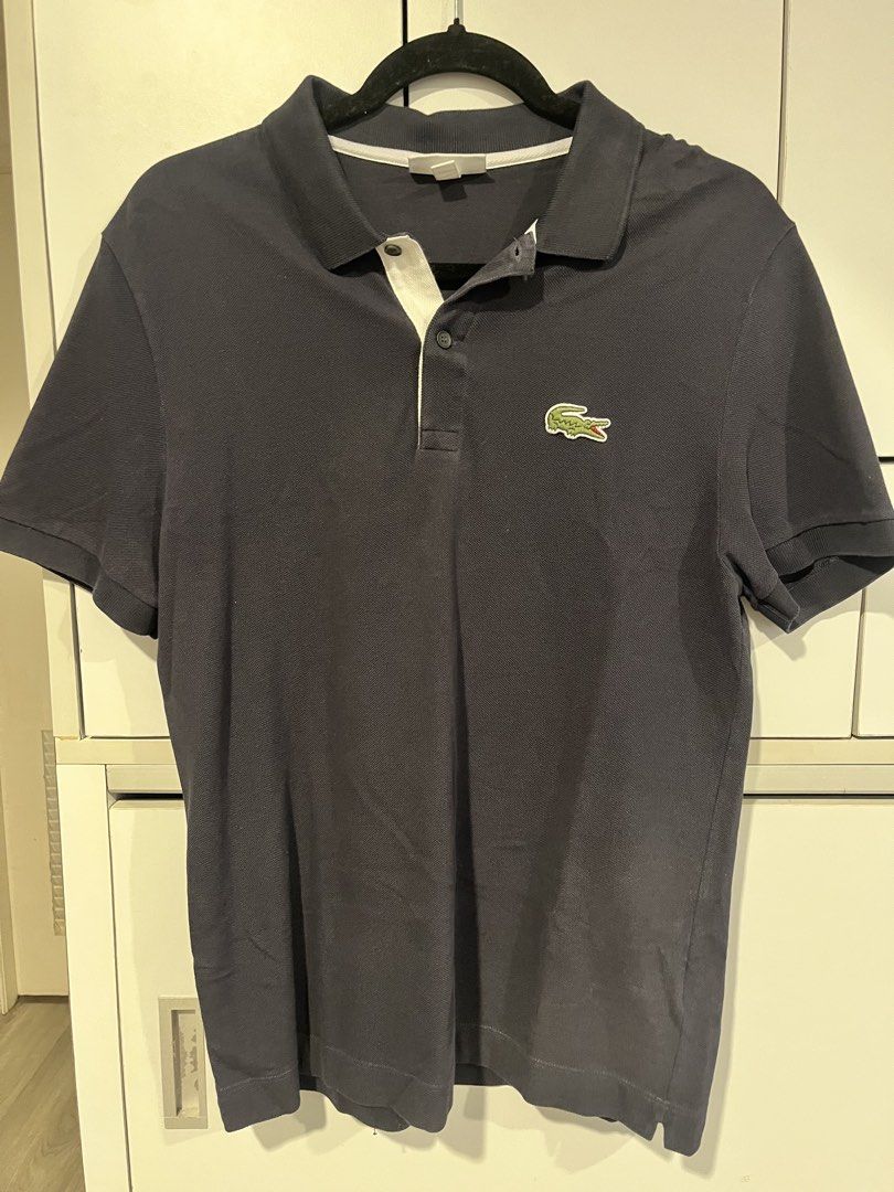 Lacoste Navy Blue Polo Shirt (Category: Tshirts & Polo Shirts ) located in Calamba. Submitted by al.nicole (Listing ID 1436942867, Image 1). Description: - Navy blue Lacoste polo shirt - Iconic green crocodile logo - White collar lining - Short-sleeved - Comfortable fabric - Perfect for casual wear - Simple and versatile design - Size FR5 - Faded marks due to laundry - Reduced size due to laundry.