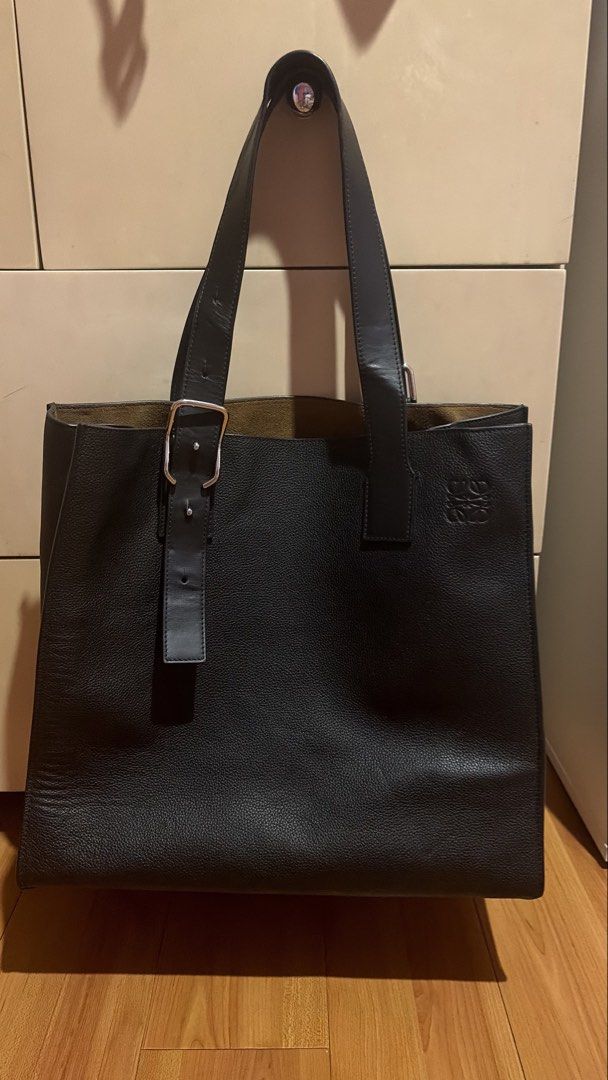 Loewe Tote Bag (Category: Luxury Bags & Wallets) located in Quezon City. Submitted by qsersera (Listing ID 1436989601, Image 1). Description: - Loewe black leather tote bag - Buckle detail on front - Spacious interior - Embossed Loewe logo - Two top handles.