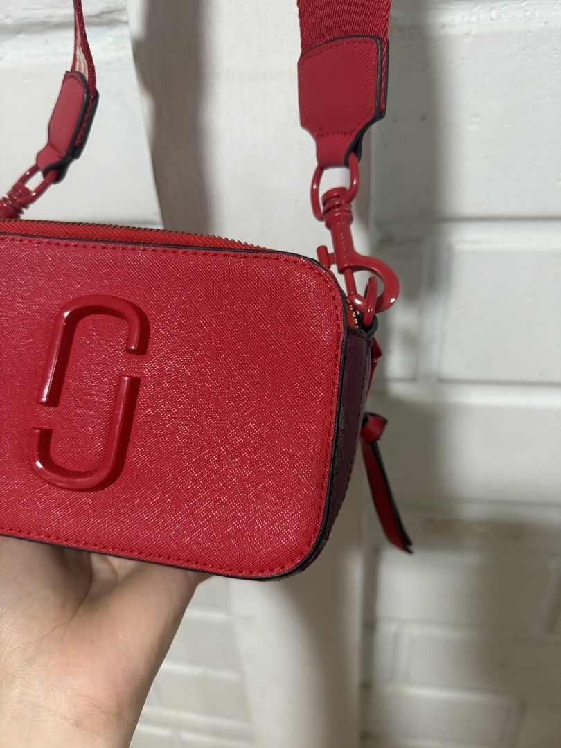 Marc Jacobs Red Crossbody Bag (Category: Luxury Bags & Wallets) located in Santa Rosa. Submitted by pamobs (Listing ID 1436899804, Image 3). Description: - Red Marc Jacobs crossbody bag - Detachable, patterned strap - Secure zip closure - Made of textured material - Vibrant red exterior - with minimal flaws on the side.