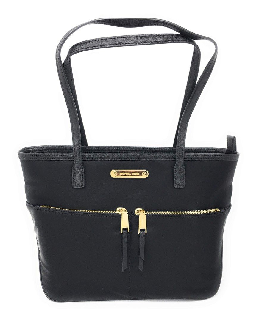 Michael Kors Nylon Black Tote Bag (Category: Tote Bags) located in Pasay City. Submitted by laann00 (Listing ID 1437017327, Image 1). Description: Lightly used Black Michael Kors tote bag with gold-toned hardware. Features two front zipper pockets and a spacious interior with the Michael Kors logo lining. Includes two top handles for carrying. Minor flaw shown in pic ( 1 handle). RFS decluttering..