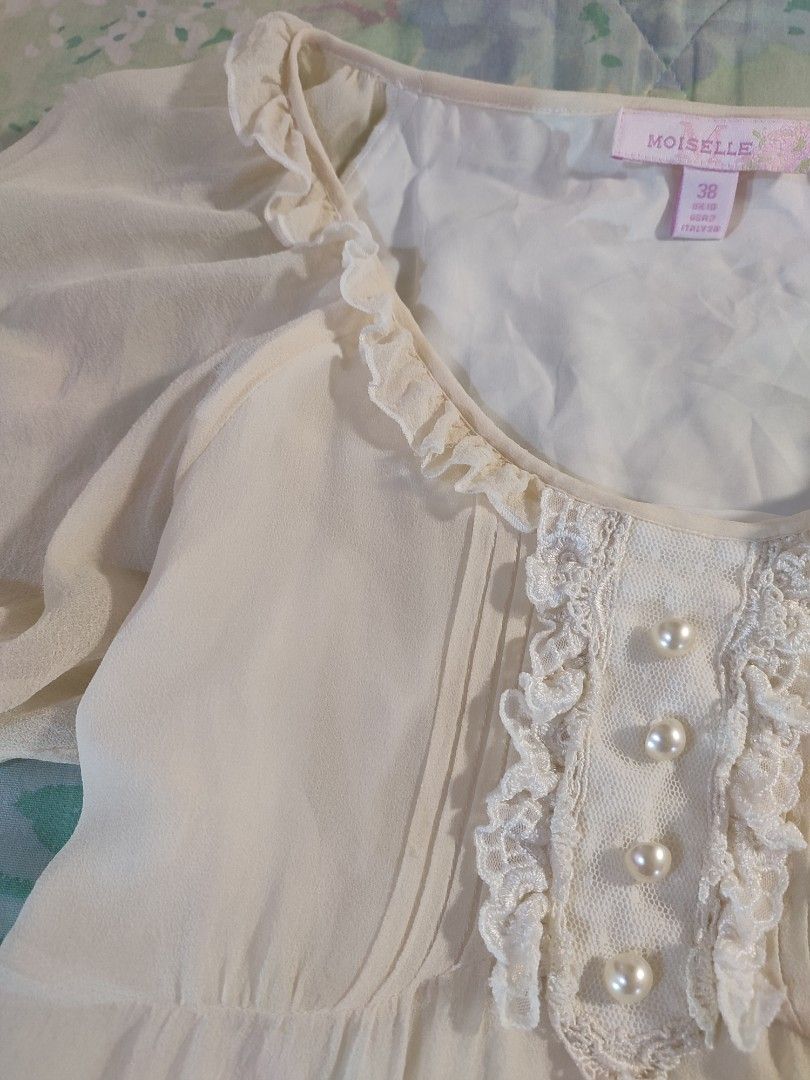 Moiselle 100% Silk Blouse with embroidery (Category: Blouses) located in Jaen. Submitted by roxantiago (Listing ID 1437001824, Image 2). Description: - Moiselle blouse - Size 38 - Cream-colored fabric - Floral accents - Round neckline with lace and pearl button details - Short, puffy sleeves - Made in Italy XS to S very pretty! flaw: minimal stain at the back and tiny holes sa sleeves (see last 2 photos).