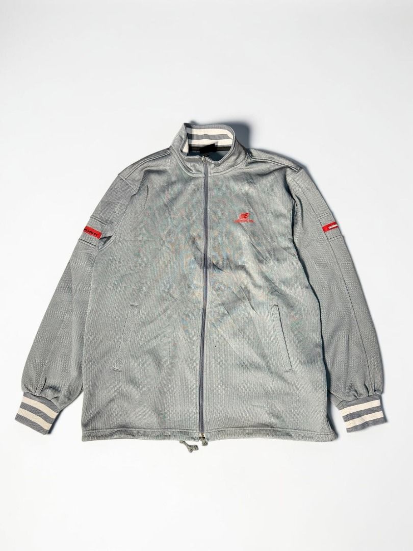 New Balance Track Jacket (Category: Coats, Jackets and Outerwear) located in Manila. Submitted by playingros58430 (Listing ID 1436991350, Image 1). Description: Gray New Balance track jacket with a full zip closure. Features a red New Balance logo on the chest and red accents on the sleeves. The jacket has a stand-up collar with striped detailing and ribbed cuffs. It also has two front pockets. Excellent Condition Color rate: 10/10 Issue: Need wa
