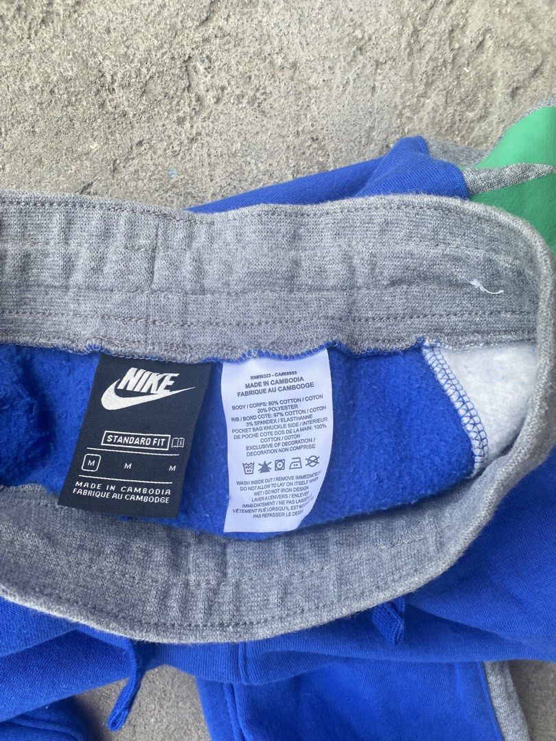 Nike Standard Fit Sweatpants - Blue (Category: Joggers) located in Manila. Submitted by keenriver-4b36 (Listing ID 1437008640, Image 3). Description: - Nike Standard Fit sweatpants - Color: Blue with grey accents - Features: Drawstring waistband, green Nike logo - Size: M - Made in Cambodia - Comfortable fit - Suitable for casual wear and workouts - Soft and durable fabric.