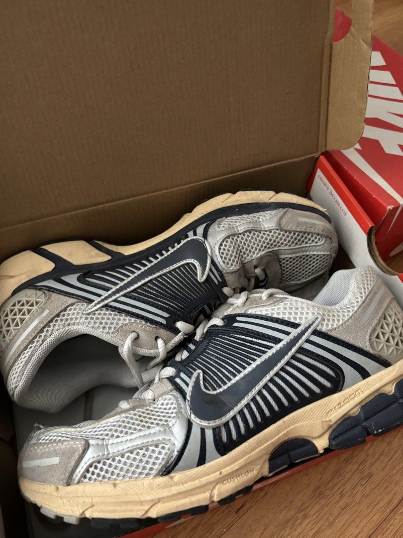 Nike Zoom Vomero 5 Thunder Blue (Category: Sneakers) located in Quezon City. Submitted by dan.bam (Listing ID 1436919985, Image 3). Description: - Nike Zoom Vomero 5 sneakers - Size: US 9.5 - Colorway: White and grey with silver and navy accents - Features a mesh upper - Condition: Worn aesthetic, soles show wear - Includes Nike box NOT AUTHHH - WHAT YOU SEE IS WHAT YOU GET - BUY AT YOUR OWN RISK.