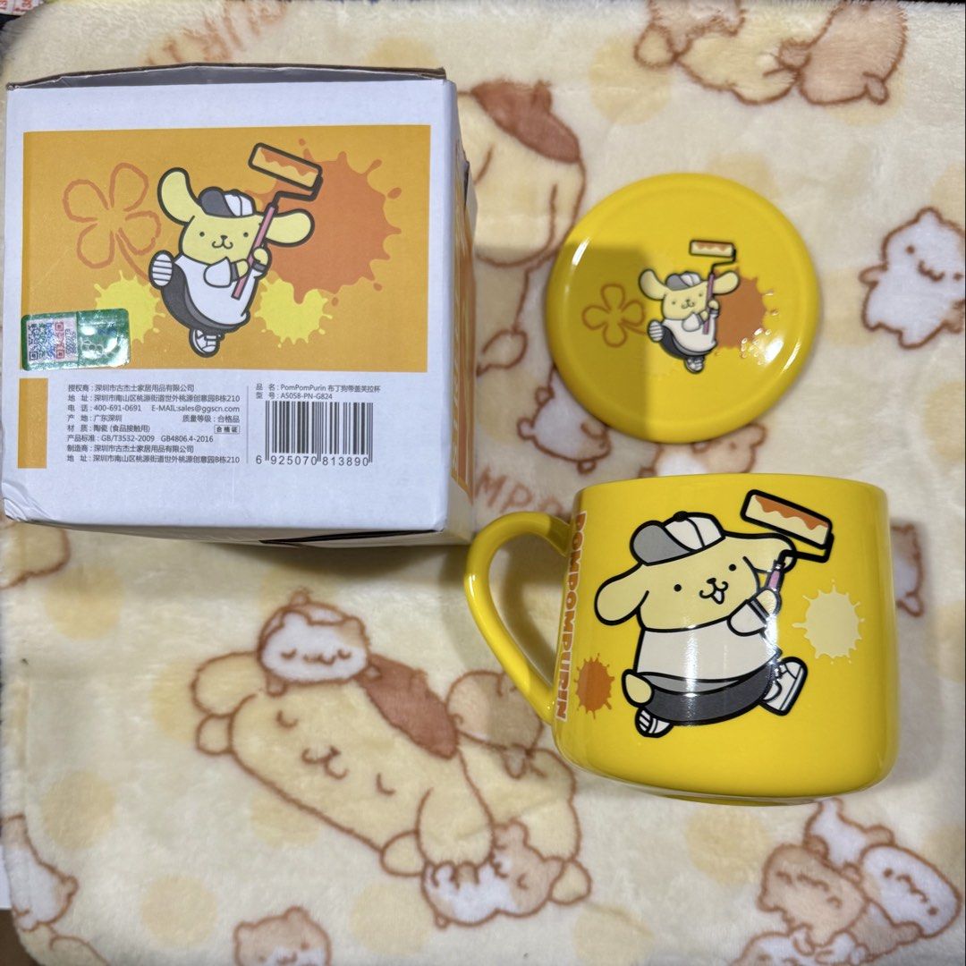 Pompompurin Ceramic Mug with Lid (Category: Coffee & Tea Tableware) located in Taguig. Submitted by karabelle19923 (Listing ID 1436994092, Image 2). Description: - sanrio license - Pompompurin mug with matching lid. - Features a yellow design. - Design: Pompompurin holding a paint roller. - Made of ceramic - Comes in original box. - Mug has a handle. - Lid also has a Pompompurin design..