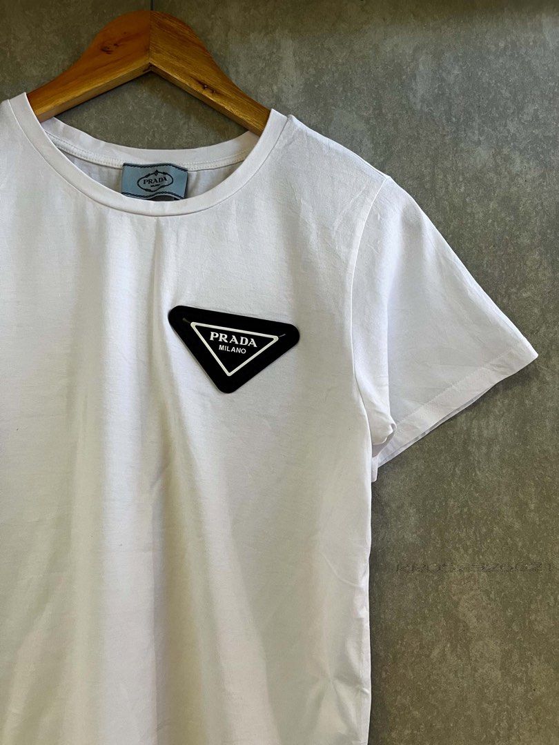 Prada Milano White T-Shirt (Category: Tshirts & Polo Shirts ) located in Bacolod City. Submitted by unkemptrags (Listing ID 1436956831, Image 3). Description: - Prada white t-shirt - Black triangle logo patch on chest - 17.5by26 -excellent condition -849 freeship.