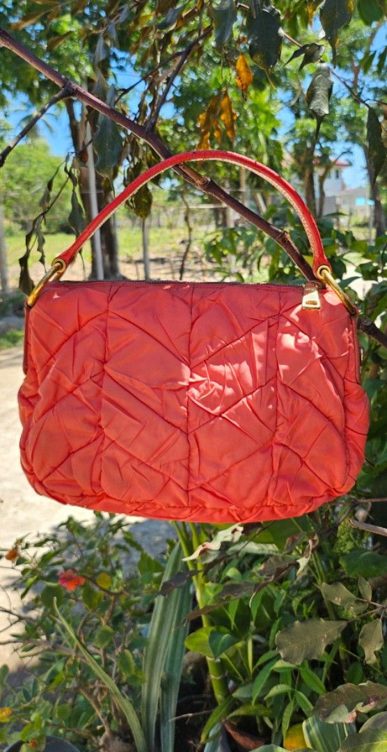 Prada Quilted Hobo Bag (Category: Luxury Bags & Wallets) located in Pamplona. Submitted by luxuryitems_ph (Listing ID 1436832794, Image 2). Description: - Authentic Prada handbag - Quilted design in a vibrant orange color - Top handle for carrying - Elegant gold-tone hardware - Features the classic Prada logo - Unique stitching pattern - Structured shape - Durable leather handle -Has washable dirt on nylon .