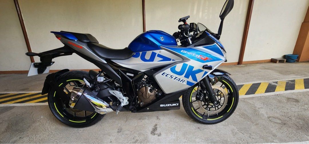 Suzuki Gixxer SF 250 (Category: Motorbikes for Sale) located in Manila. Submitted by riadananapalcruz79 (Listing ID 1436979388, Image 1). Description: Suzuki Gixxer SF 250 motorcycle with blue and silver color scheme. Features include a sporty design, black wheels with yellow accents, and a visible exhaust. The bike has the Suzuki and Ecstar branding. Original paper brand new last year lng binili 1k odo lng po owner nsa ibang bansa pero ready n u