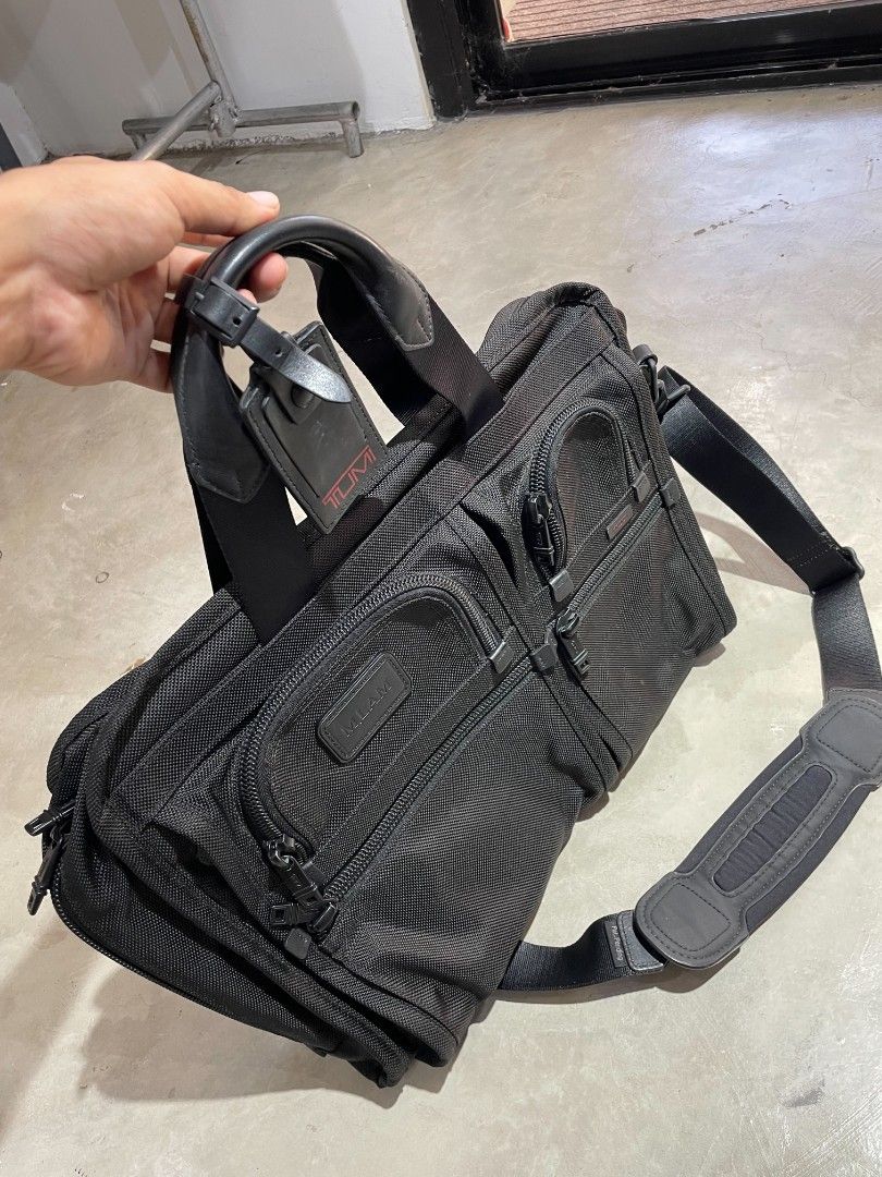 Tumi Black Briefcase (Category: Briefcases) located in Quezon City. Submitted by edwinvuru (Listing ID 1436901396, Image 3). Description: - Black Tumi briefcase - Multiple compartments for organization - Comfortable leather handle - Includes a detachable shoulder strap - Features a luggage tag - Exterior zippered pockets for easy access - Interior zippered compartment - Padded shoulder strap for comfort - Includes a barcode tag.