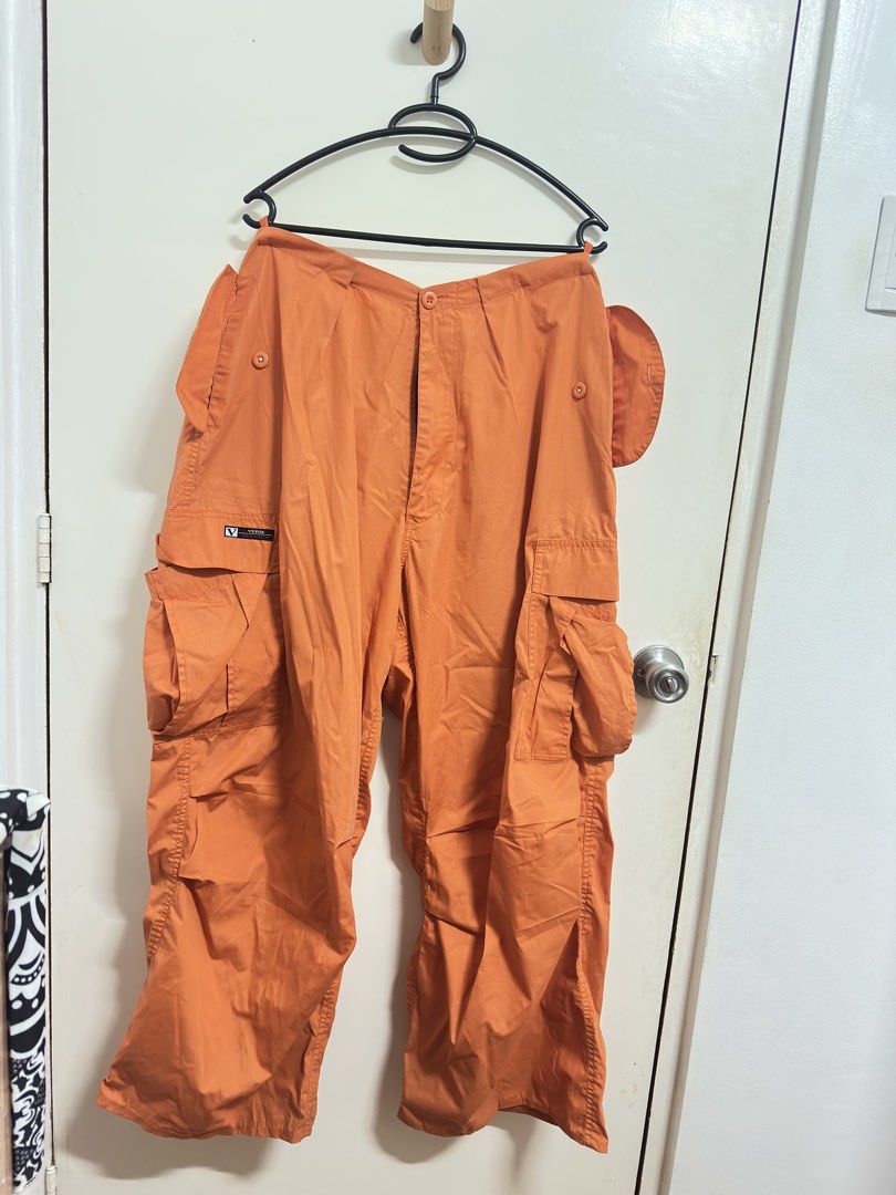 Verge Orange Cargo Pants (Category: Other Bottoms) located in Manila. Submitted by hutfris (Listing ID 1436888855, Image 3). Description: - Verge orange cargo pants - Multiple pockets (front and sides) - Button closure at waist - Button detail on side pockets - Verge logo detail - Solid orange color.