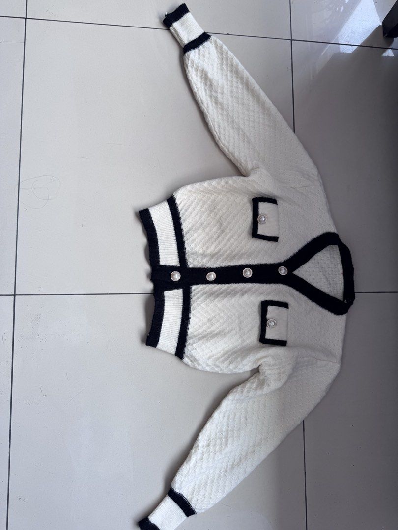 White and Black Knit Cardigan (Category: Coats, Jackets and Outerwear) located in Manila. Submitted by decluterthings888 (Listing ID 1437016794, Image 1). Description: - White knit cardigan with black trim - V-neckline - Long sleeves - Two front pockets - Pearl-like buttons - Quilted texture - Adds sophistication to any outfit.