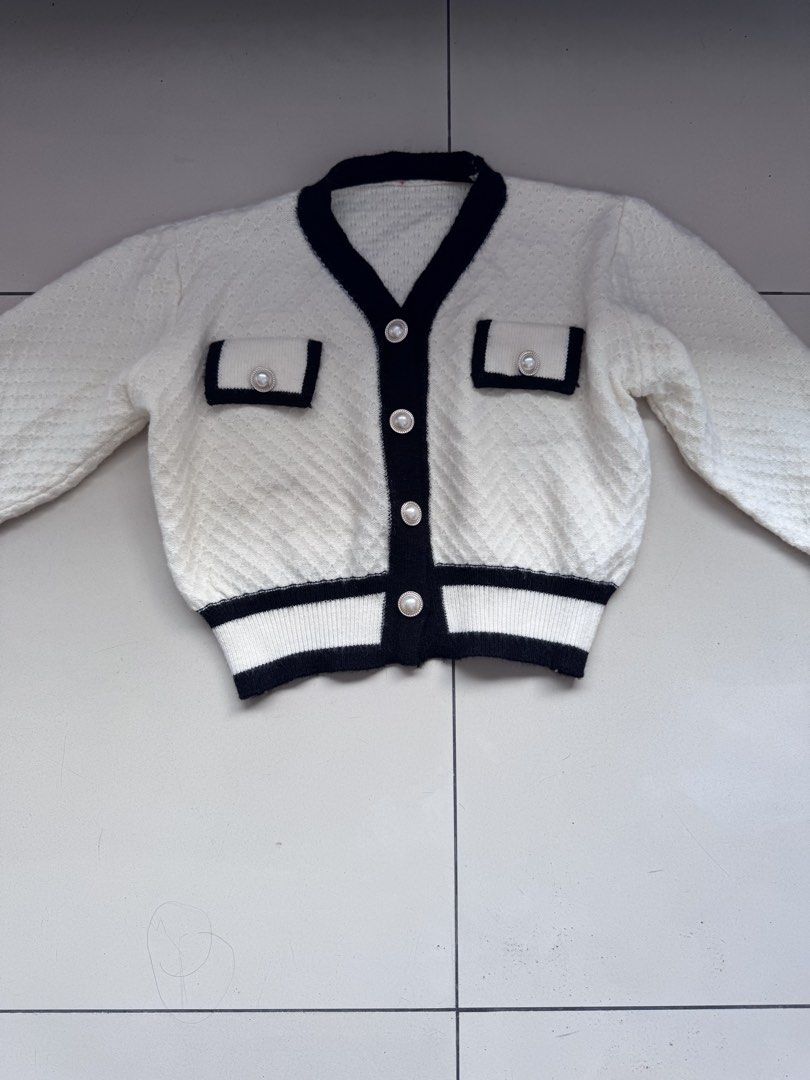 White and Black Knit Cardigan (Category: Coats, Jackets and Outerwear) located in Manila. Submitted by decluterthings888 (Listing ID 1437016794, Image 2). Description: - White knit cardigan with black trim - V-neckline - Long sleeves - Two front pockets - Pearl-like buttons - Quilted texture - Adds sophistication to any outfit.