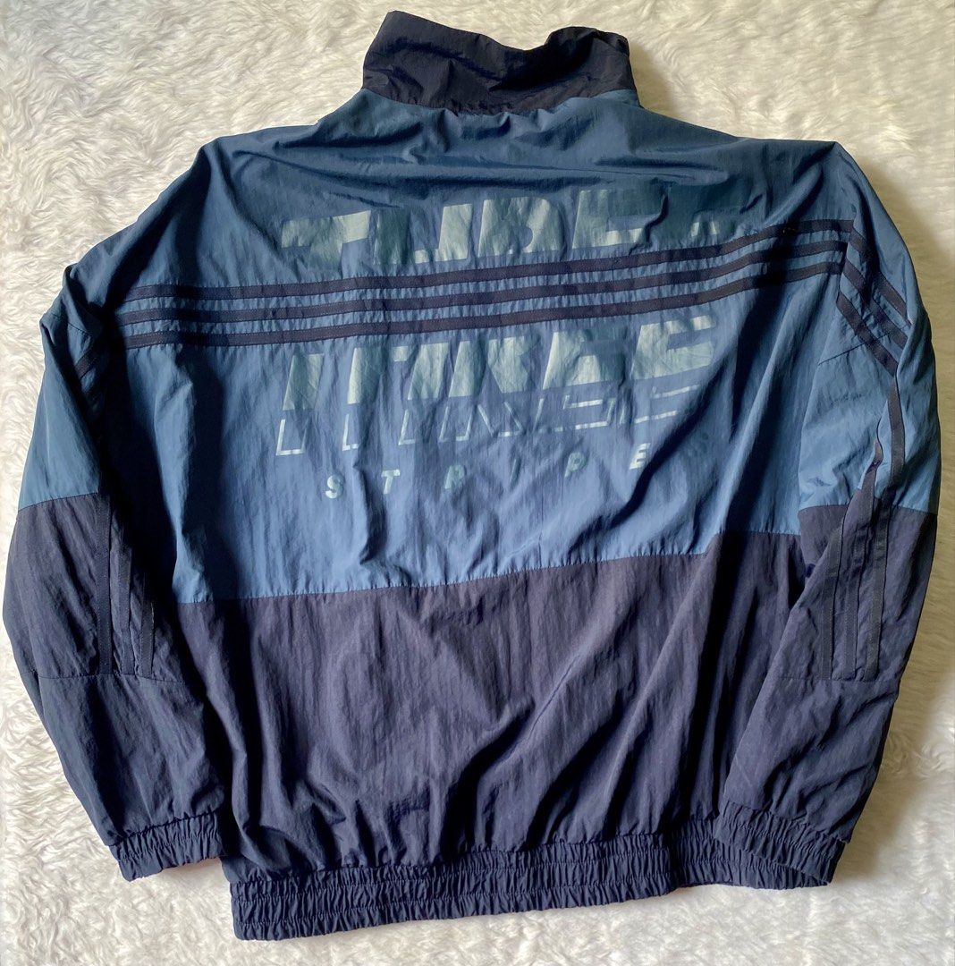 Adidas Wording Woven Windbreaker Track Jacket (Category: Coats, Jackets and Outerwear) located in Quezon City. Submitted by getgetpao (Listing ID 1441343736, Image 2). Description: Size on tag A/L 27”Lx26”W Issues : stain, sign of usage and minimal damage print (see photos) Washed. Very good condition - Classic Adidas track jacket - Iconic three stripes on sleeves - Two-tone blue and navy colorway - Zipper closure with stand-up collar - Elasticat
