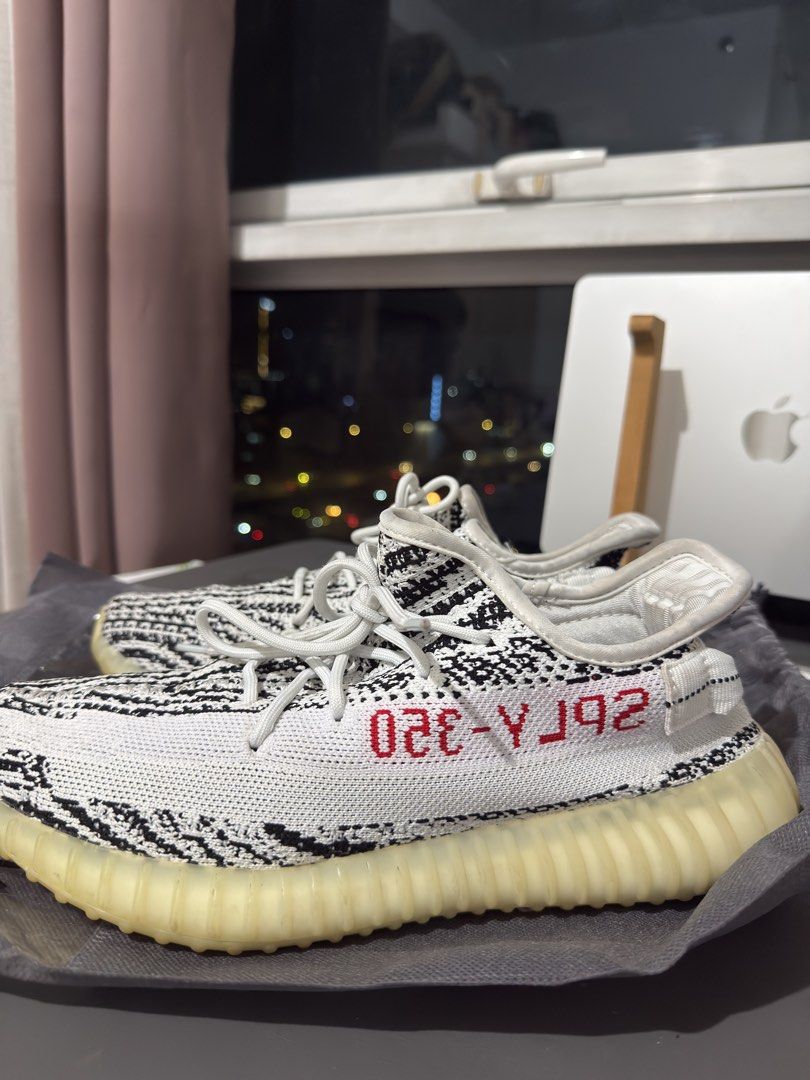 Adidas Yeezy Boost 350 V2 Zebra (Category: Sneakers) located in Manila. Submitted by maviemavz (Listing ID 1441291153, Image 2). Description: - Authentic Adidas Yeezy Boost 350 V2 Zebra - Classic black and white stripe pattern - Bold red 'SPLY-350' branding on the side - Signature translucent sole - Crisp white laces - Essential addition to any sneaker collection.