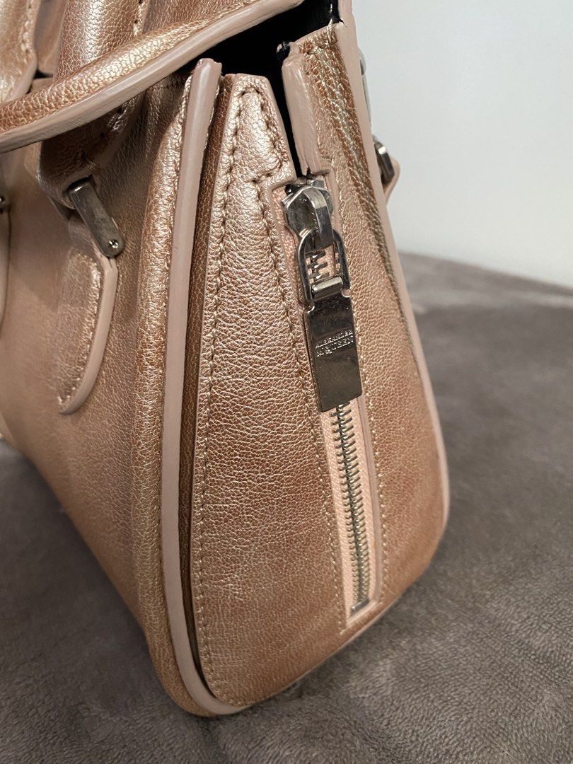 Alexander McQueen Metallic Rose Gold Mini Bag (Category: Luxury Bags & Wallets) located in Caloocan City. Submitted by chiqiqayshop (Listing ID 1441290974, Image 2). Description: - Metallic rose gold mini bag - Genuine leather - Top handles - Detachable shoulder strap - Side zipper closure - Interior pocket - Ideal for night outs or adding a pop of color.