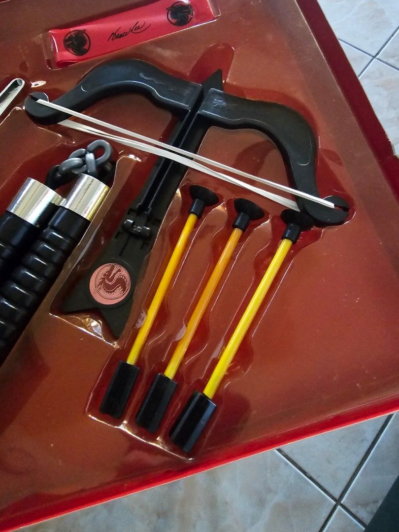 Bruce Lee Dagger and Crossbow Toy Set (Category: Action & Battle Toys) located in Muntinlupa City. Submitted by jojiepogi123 (Listing ID 1441236473, Image 3). Description: - Vintage Bruce Lee toy set - Includes dagger, nunchucks, throwing stars, and crossbow with arrows - Packaging shows some wear - Contents appear complete - Great for collectors and Bruce Lee fans - Fun piece of memorabilia.