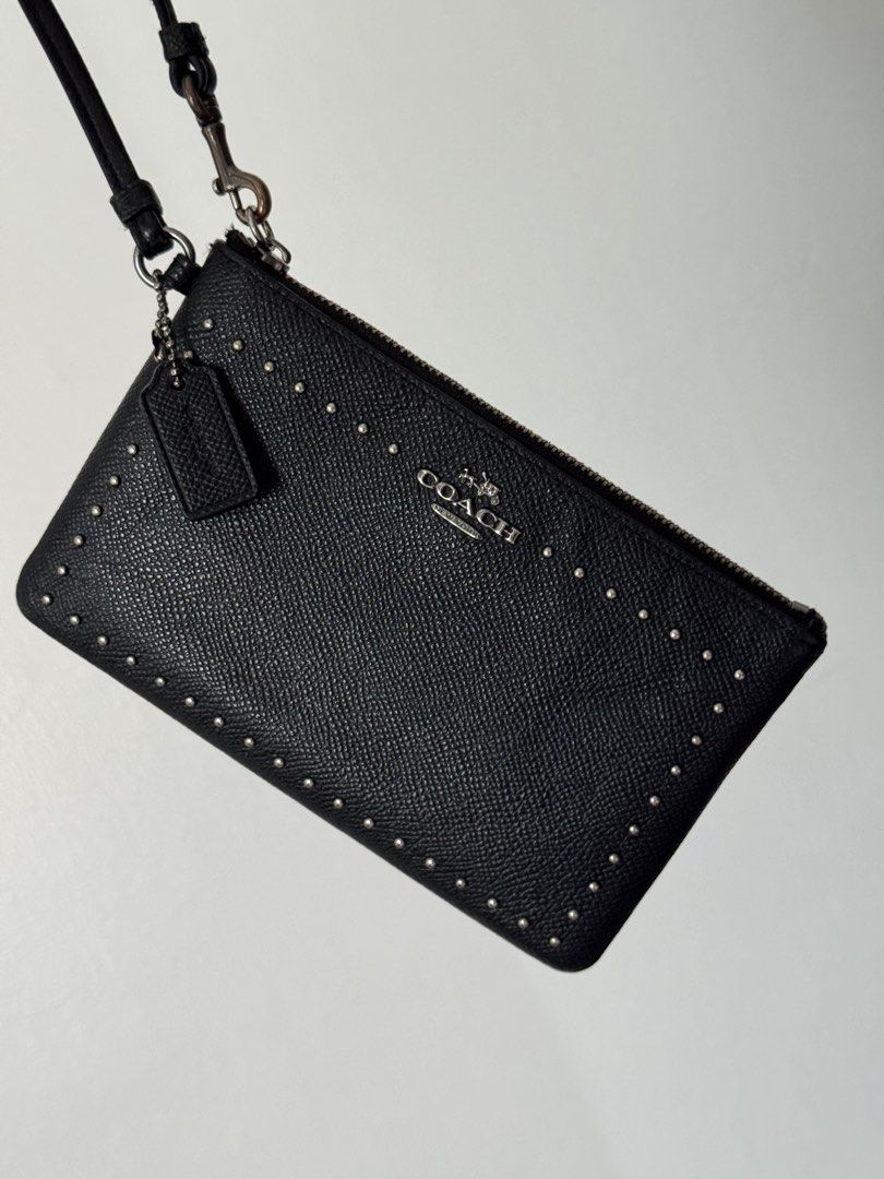Coach Black Studded Leather Wristlet Pouch (Category: Luxury Bags & Wallets) located in Quezon City. Submitted by nbg.declutter (Listing ID 1441211437, Image 3). Description: - Authentic Coach black leather wristlet - Stylish studded detailing on the front - Secure zipper closure - Detachable wrist strap for versatility - Includes small Coach brand tag - Ideal for carrying your daily essentials.