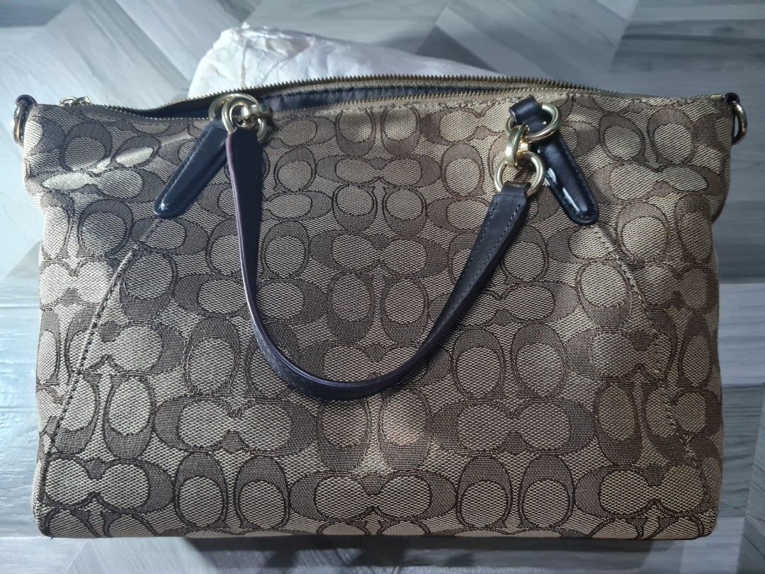 Coach Signature Canvas Shoulder Bag with Strap (Category: Luxury Bags & Wallets) located in Batangas. Submitted by mariroz (Listing ID 1441309102, Image 3). Description: - 100 💯 Authentic Coach shoulder bag in brown and gold signature canvas. - Bought from Coach Japan - Textured canvas finish for a stylish look. - Elegant gold hardware details throughout. - Includes a detachable dark brown leather strap. - Strap features the classic Coach horse 