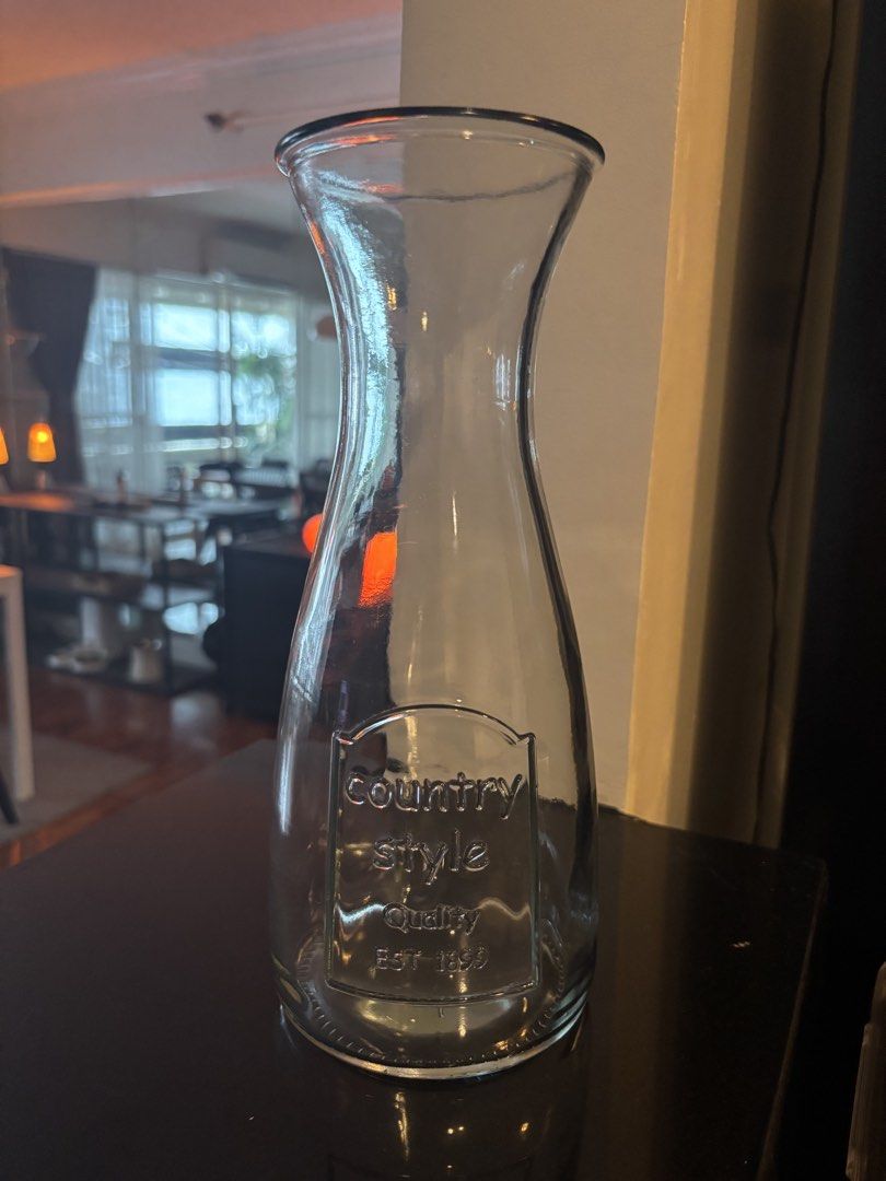 Country Style Quality Glass Pitcher (Category: Pitchers & Dispensers) located in Manila. Submitted by ahamburger (Listing ID 1441235766, Image 1). Description: - Clear glass pitcher with a unique curved shape. - Features an embossed 'country style Quality EST 1899' label on the front. - Ideal for serving water, juices, or other beverages. - Adds a charming rustic and vintage aesthetic to your table setting. - Durable and suitable for everyday use