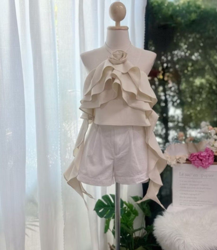 Cream Ruffle Halter Top (Category: Sleeveless) located in Taguig. Submitted by chicstyle (Listing ID 1441285167, Image 1). Description: - Adorable cream halter top with charming ruffles and a delicate rose accent. - Features adjustable tie details on the sides of the top. - Versatile set, perfect for summer days, vacations, or styling pieces individually..