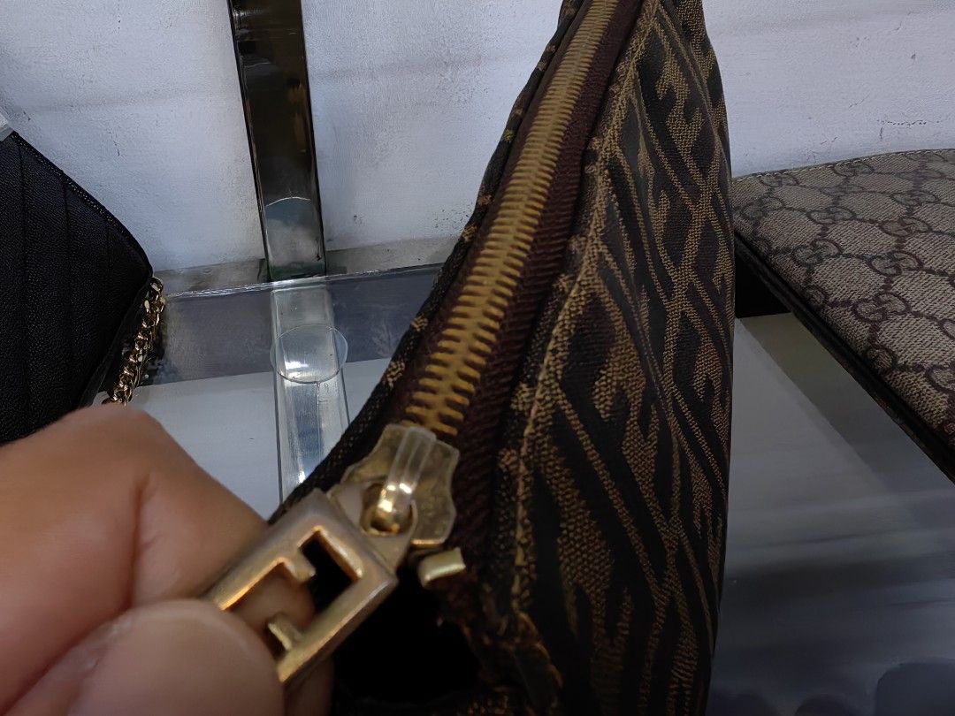 Fendi Zucca Monogram Pouch (Category: Luxury Bags & Wallets) located in Quezon City. Submitted by flat.earther23 (Listing ID 1441182135, Image 3). Description: - Authentic Fendi Zucca monogram pouch - Color: Brown and tan canvas - Closure: Zipper - Interior: Zippered pocket - Hardware: Gold tone - Ideal for carrying essentials.