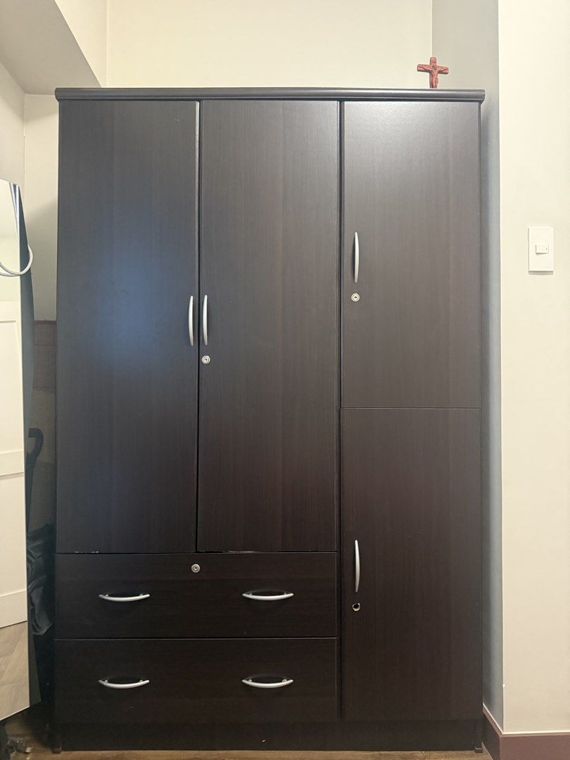 Dark Brown Wardrobe / Cabinet with Drawers (Category: Shelves, Cabinets & Racks) located in Mandaluyong City. Submitted by prelovedbyn_ph (Listing ID 1441182992, Image 2). Description: Condition: - Used condition - Drawers and cabinet doors are functional - Visible scratches and chipped laminate from normal use - One side panel has a hole/damage (shown in photos) - Some handle wear and cosmetic imperfections - Structurally usable despite cosmetic