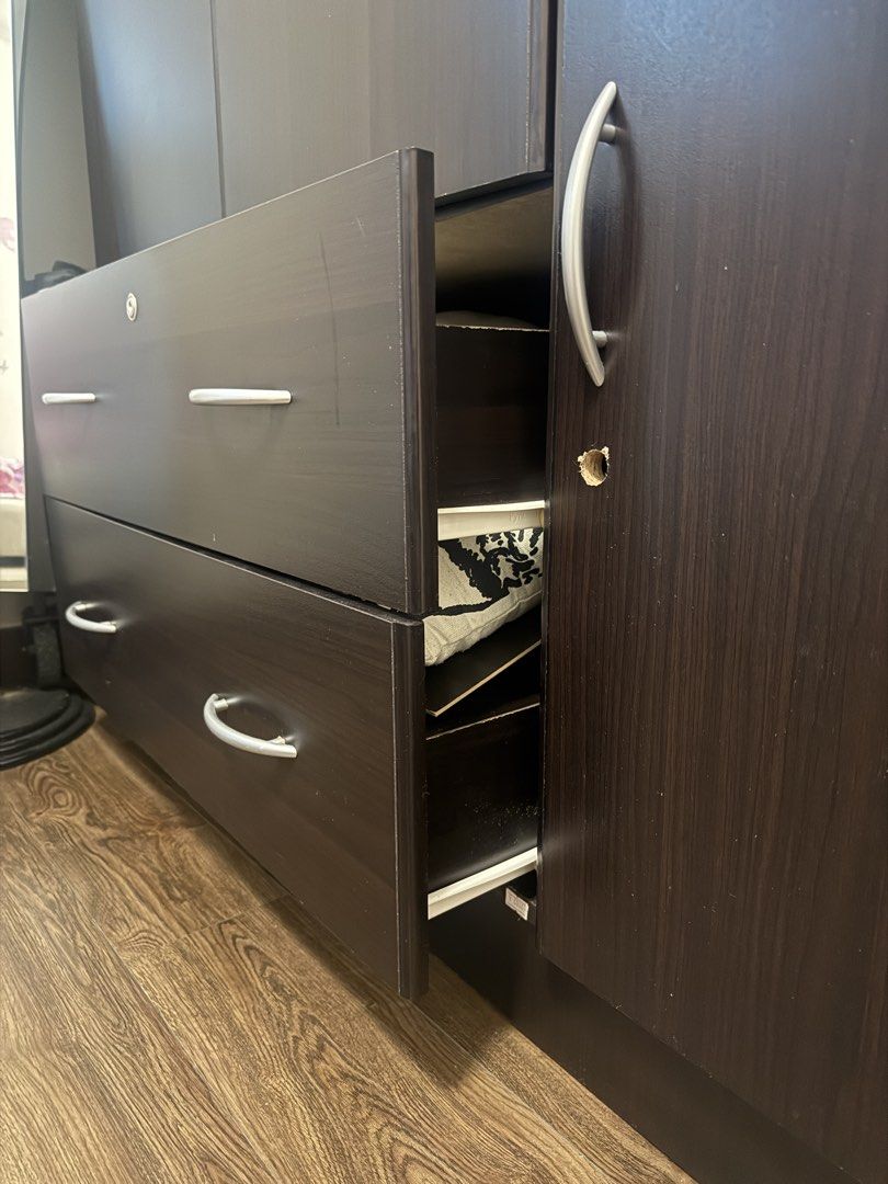 Dark Brown Wardrobe / Cabinet with Drawers (Category: Shelves, Cabinets & Racks) located in Mandaluyong City. Submitted by prelovedbyn_ph (Listing ID 1441182992, Image 3). Description: Condition: - Used condition - Drawers and cabinet doors are functional - Visible scratches and chipped laminate from normal use - One side panel has a hole/damage (shown in photos) - Some handle wear and cosmetic imperfections - Structurally usable despite cosmetic