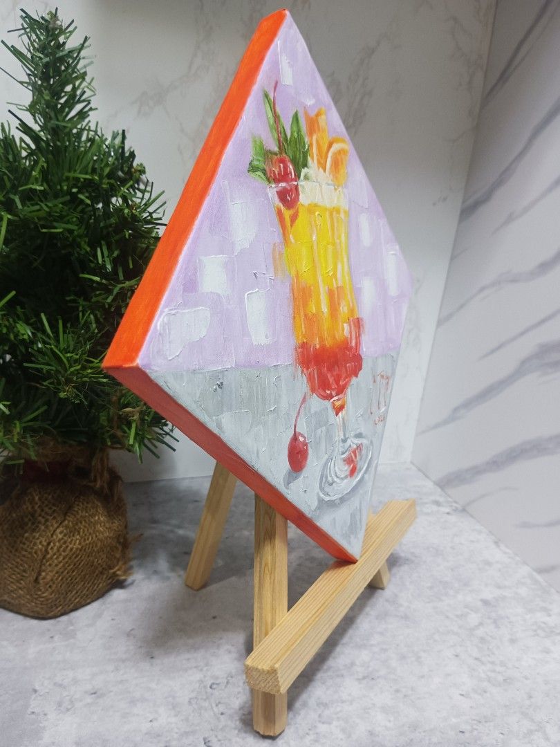 Handmade Cocktail Painting on Canvas (Category: Art & Prints) located in Mandaluyong City. Submitted by alexstan2716850 (Listing ID 1441169173, Image 2). Description: - Original painting of a colorful cocktail, resembling a Tequila Sunrise. - Unique diamond-shaped canvas. - Sides are painted orange for a finished look. - Signed by the artist on the front. - Comes with a small wooden easel, ready for display. - Ideal decor for your kitchen or bar 