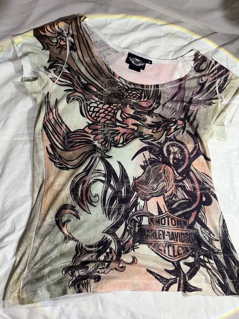 Harley-Davidson Graphic T-Shirt (Category: Tshirts & Polo Shirts ) located in Manila. Submitted by ines_montgomery (Listing ID 1441251157, Image 1). Description: - Cool graphic tee - Features a dragon and Harley-Davidson logo - Short sleeves, scoop neck - Faded, vintage print - Size M - Perfect for Harley fans.