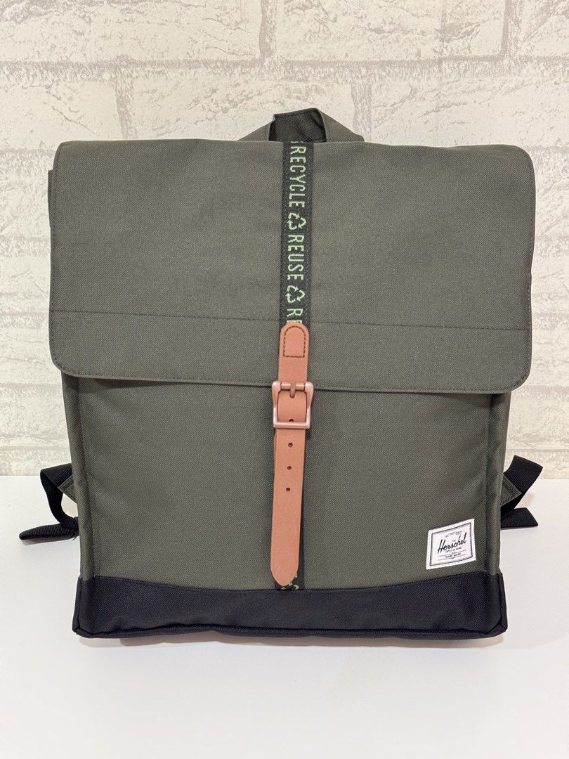 Herschel Supply Co. City Mid-Volume Backpack - Olive (Category: Backpacks) located in Mandaluyong City. Submitted by axelottle (Listing ID 1441296186, Image 2). Description: - Herschel Supply Co. City Mid-Volume backpack - Color: Olive Green - Closure: Flap with buckle strap - Front pocket: Zip closure - Straps: Feature 'Recycle, Reuse, Recycle' print - Material: 100% recycled materials - Condition: Comes with original packaging.