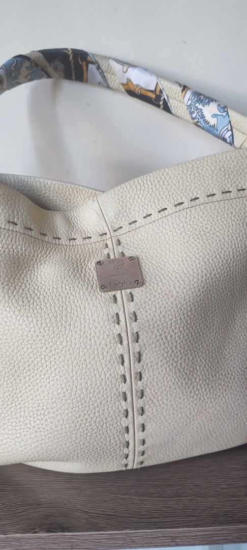MCM Leather Hobo Bag (Category: Luxury Bags & Wallets) located in Caloocan City. Submitted by guiltypleasures75 (Listing ID 1441229501, Image 2). Description: MCM Vintage hobo bag in cream leather (free twilly) - Stylish contrast stitching - Convenient exterior pockets - Fun, patterned interior lining - MCM logo zipper pull - Secure magnetic snap closure - Ideal for everyday carry with sign of usage.