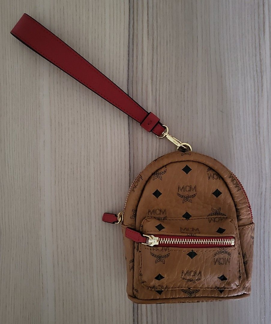MCM wristlet bag (Category: Luxury Bags & Wallets) located in Taguig. Submitted by MOJO68 (Listing ID 1441201227, Image 1). Description: MCM Cognac Visetos Coated Canvas and Leather Backpack Wristlet Pouch. This wristlet pouch from the House of MCM is made to grant style and panache. It is made from Cognac Visetos canvas and leather on the exterior and features gold-toned hardware and an Alcantara-lined interior. This pouch is practical for every
