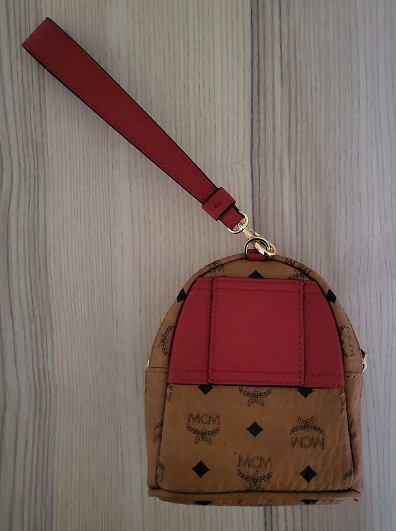MCM wristlet bag (Category: Luxury Bags & Wallets) located in Taguig. Submitted by MOJO68 (Listing ID 1441201227, Image 2). Description: MCM Cognac Visetos Coated Canvas and Leather Backpack Wristlet Pouch. This wristlet pouch from the House of MCM is made to grant style and panache. It is made from Cognac Visetos canvas and leather on the exterior and features gold-toned hardware and an Alcantara-lined interior. This pouch is practical for every