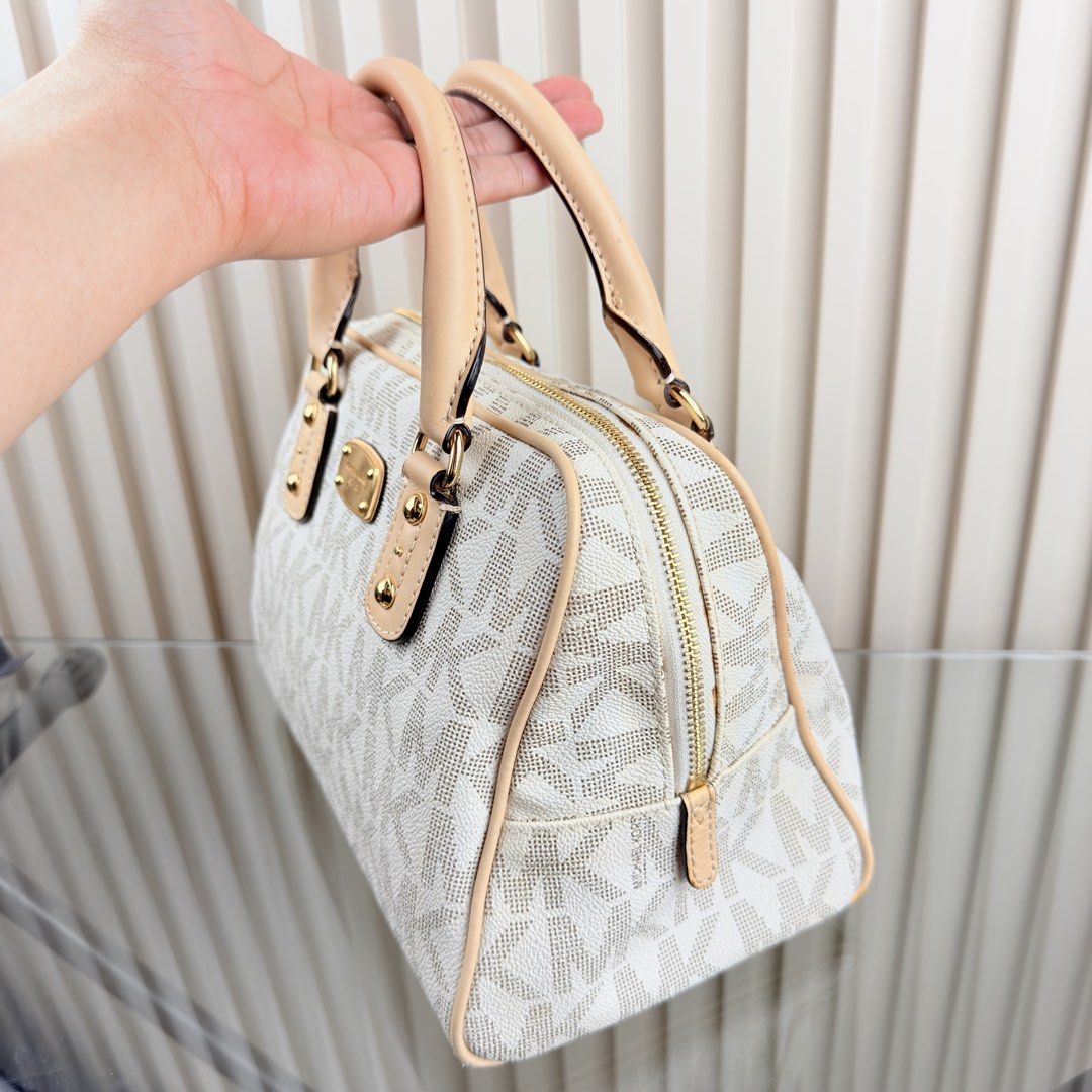 Michael Kors Monogrammed Dome Satchel Bag (Category: Luxury Bags & Wallets) located in Pasig City. Submitted by trendapparelph (Listing ID 1441198880, Image 2). Description: - Authentic Michael Kors satchel in white and beige. - Features the iconic MK monogram print all over. - Accented with elegant tan leather trim and handles. - Stylish gold hardware details. - Secure zipper closure for your essentials. - Includes original small card. - An idea