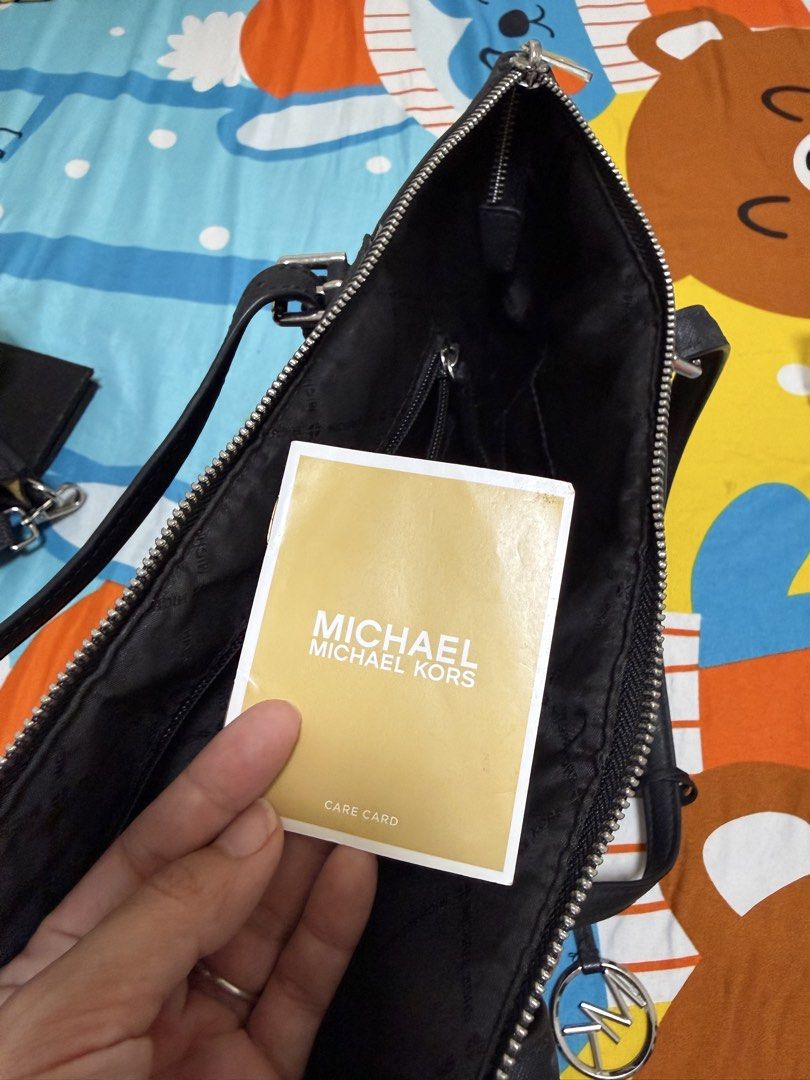 Michael Kors Tote Bag (Category: Luxury Bags & Wallets) located in Cagayan de Oro. Submitted by iammaica (Listing ID 1436815127, Image 3). Description: - Michael Kors tote bag - Classic black and gray monogram pattern - Double shoulder straps - Top zipper closure - Front pocket - Silver MK logo charm - Perfect for everyday use - Stylish and functional.