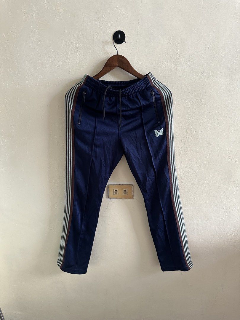 Needles Narrow Track Pants (Category: Joggers) located in Digos. Submitted by jayarshop (Listing ID 1441283046, Image 1). Description: - Navy blue Needles track pants - Iconic embroidered butterfly logo on left thigh - Signature side stripe detailing - Comfortable elastic waistband with drawstring - Secure zipped pockets (front and back) - Made in Japan - Size XS.