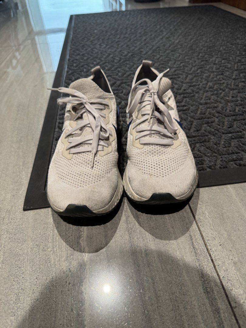 Nike Epic React 2 Flyknit Running Shoes (Category: Sneakers) located in Makati City. Submitted by gonz4669 (Listing ID 1441255913, Image 2). Description: - Nike running shoes - Light grey knit upper with blue swoosh - Versatile: suitable for running or casual wear.