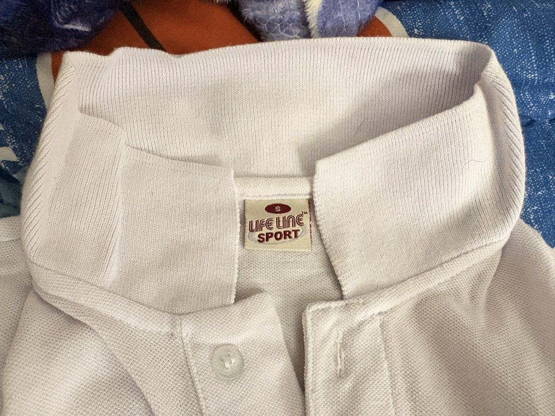 Plain white polo for sports (Category: Tshirts & Polo Shirts ) located in Makati City. Submitted by ciados (Listing ID 1441353546, Image 2). Description: - White Lifeline Sport polo shirt - Short sleeves with a collar - Button closure at the neck - Simple and classic design - Perfect for casual wear or sports activities.