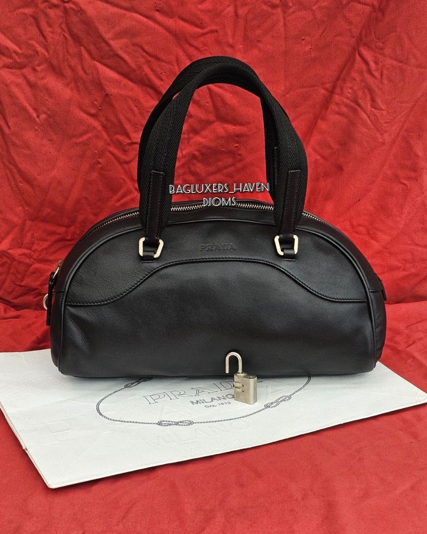 🛑Prada Black Leather Zip Bowler Bag (Category: Luxury Bags & Wallets) located in Baguio. Submitted by bagluxers_haven (Listing ID 1441302408, Image 1). Description: 🛑Authentic Prada Black Soft Calfskin Leather Zip Closure Bowler Bag w/ Dual Flat Canvas Top Handle & a Digital Padlock 》Small to medium w/ a spacious jacquard lined interior. 》Djom Djom 🛑Lightly Used, Very Good Condition but no more inclusions. No Flaw. 🛑DIMENSION : 11.5"L X 6"H X
