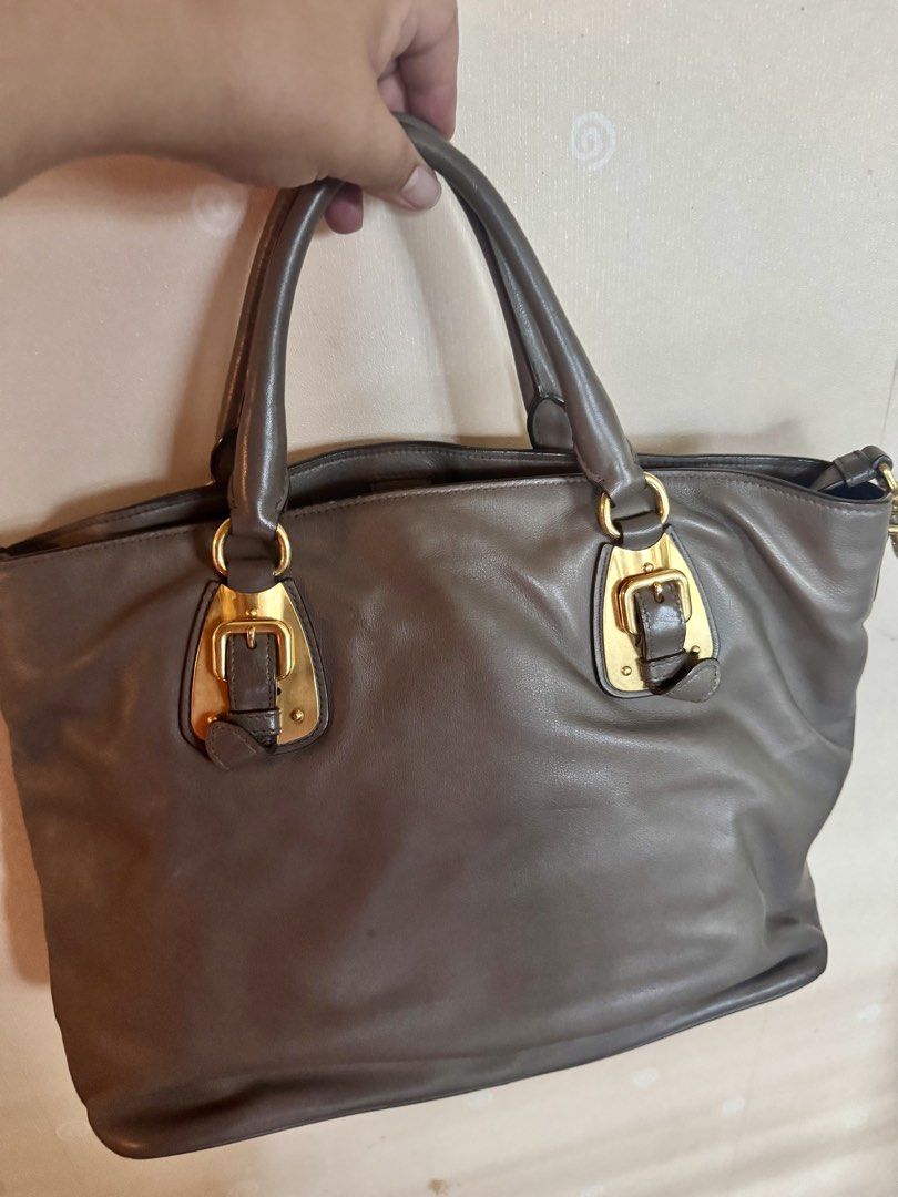 Prada Milano Leather Tote Bag Gold Hardware (Category: Luxury Bags & Wallets) located in Balagtas. Submitted by bulacan_goods (Listing ID 1441185993, Image 2). Description: - Authentic Prada Bag - Material: Soft Grey Leather - Hardware: Gold-tone - Features: Buckle details, Top handles - Interior: Spacious - Versatile: Ideal for daily use or special occasions - Style: Classic Prada piece.