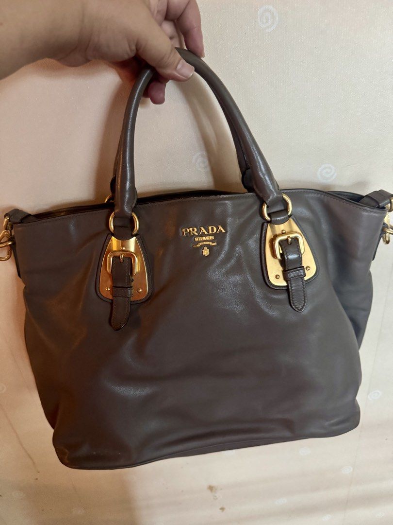 Prada Milano Leather Tote Bag Gold Hardware (Category: Luxury Bags & Wallets) located in Balagtas. Submitted by bulacan_goods (Listing ID 1441185993, Image 1). Description: - Authentic Prada Bag - Material: Soft Grey Leather - Hardware: Gold-tone - Features: Buckle details, Top handles - Interior: Spacious - Versatile: Ideal for daily use or special occasions - Style: Classic Prada piece.