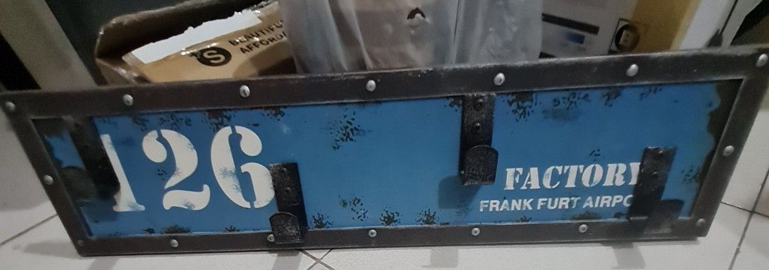 Retro wooden cloth hanger (Category: Wall Decor) located in Quezon City. Submitted by declutter1990 (Listing ID 1441163430, Image 1). Description: - Cool vintage-style sign - Features '126' and 'FACTORY FRANKFURT AIRPORT' - Metal frame with rivets - Blue distressed background - Two latches on the front - Ideal for a man cave or workshop - Approximate dimensions: 24 inches long x 6 inches tall.