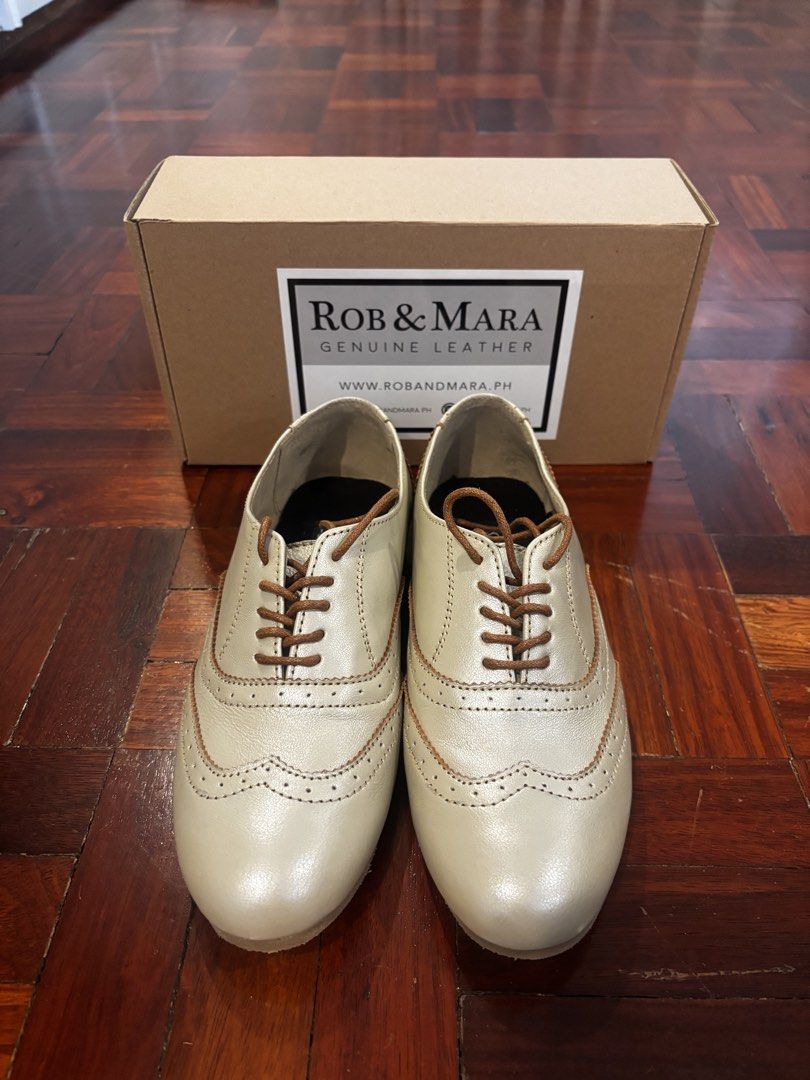 Rob & Mara Genuine Leather Wingtip Oxfords (Category: Loafers) located in Quezon City. Submitted by jcs_items (Listing ID 1441172369, Image 1). Description: - Rob & Mara genuine leather oxfords - Classic wingtip design with brogue detailing - Elegant light gold/champagne shimmer color - Durable rubber soles with R/M branding - Comes with original box.